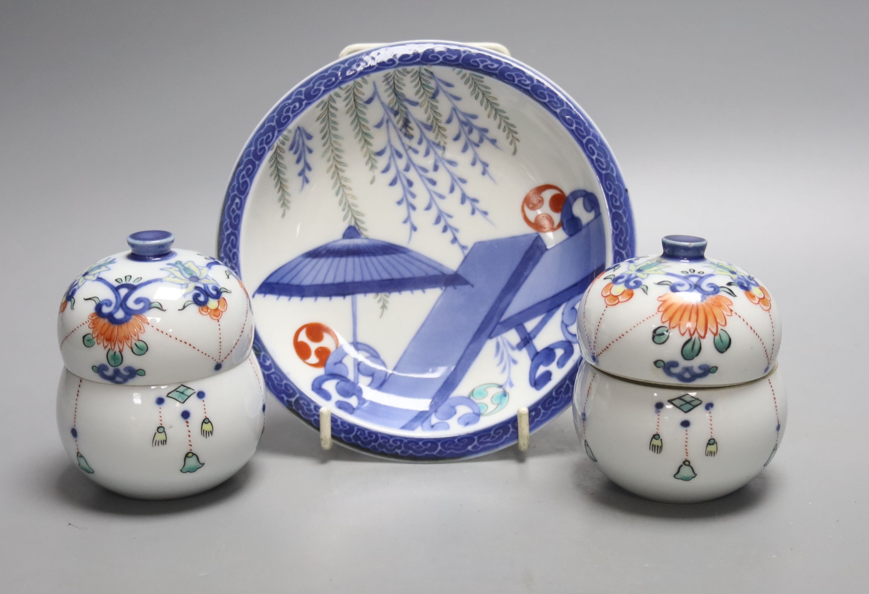 A pair of Japanese Nabeshima style jars and covers and a similar footed dish, tallest 9cm